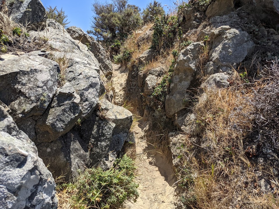 A narrow, steep path through two rocks, that are big enough to fill the image.