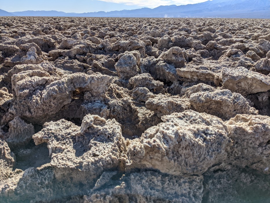 At first glance it looks like a field of rocks about a foot high stretching to the mountains in the far distance, too rough to easily walk on, but on a closer glance you can see a honeycomb texture and the salt beneath the dust.